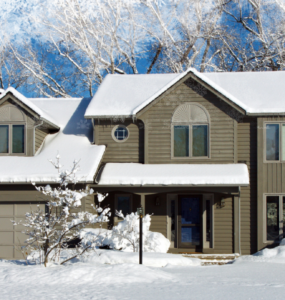 A large suburban home covered in a blanket of fresh, white snow.