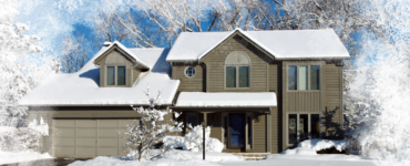 A large suburban home covered in a blanket of fresh, white snow.