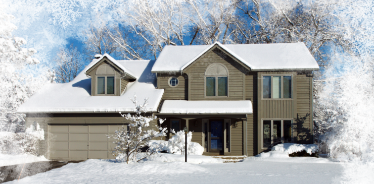 A large suburban home covered in a blanket of fresh, white snow.