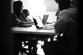 people sitting around table with laptops
