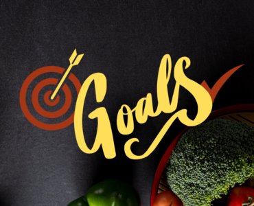 Image of heathy food and running shoes against a starck black background with the words, "Goals" written across the image.