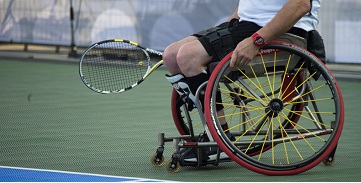 person in wheelchair playing tennis