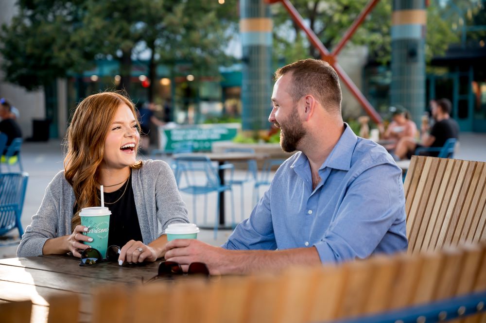 A couple laughing and drinking coffee